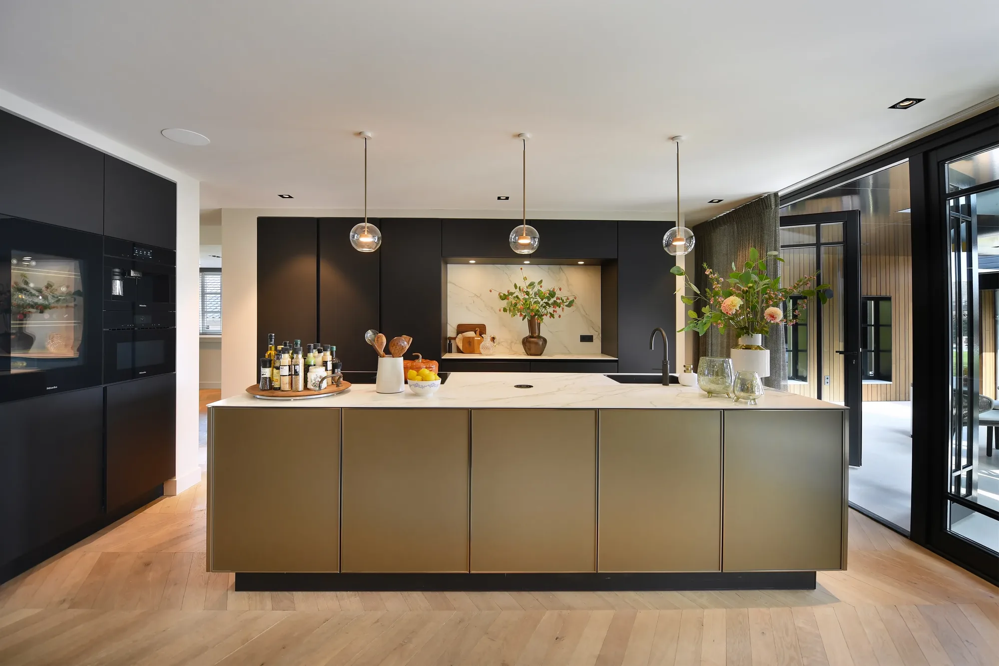 Luxe zwarte Sie Matic keuken met goudkleurig kookeiland in moderne open woonruimte TAOL ASWA Keukens 206353 3