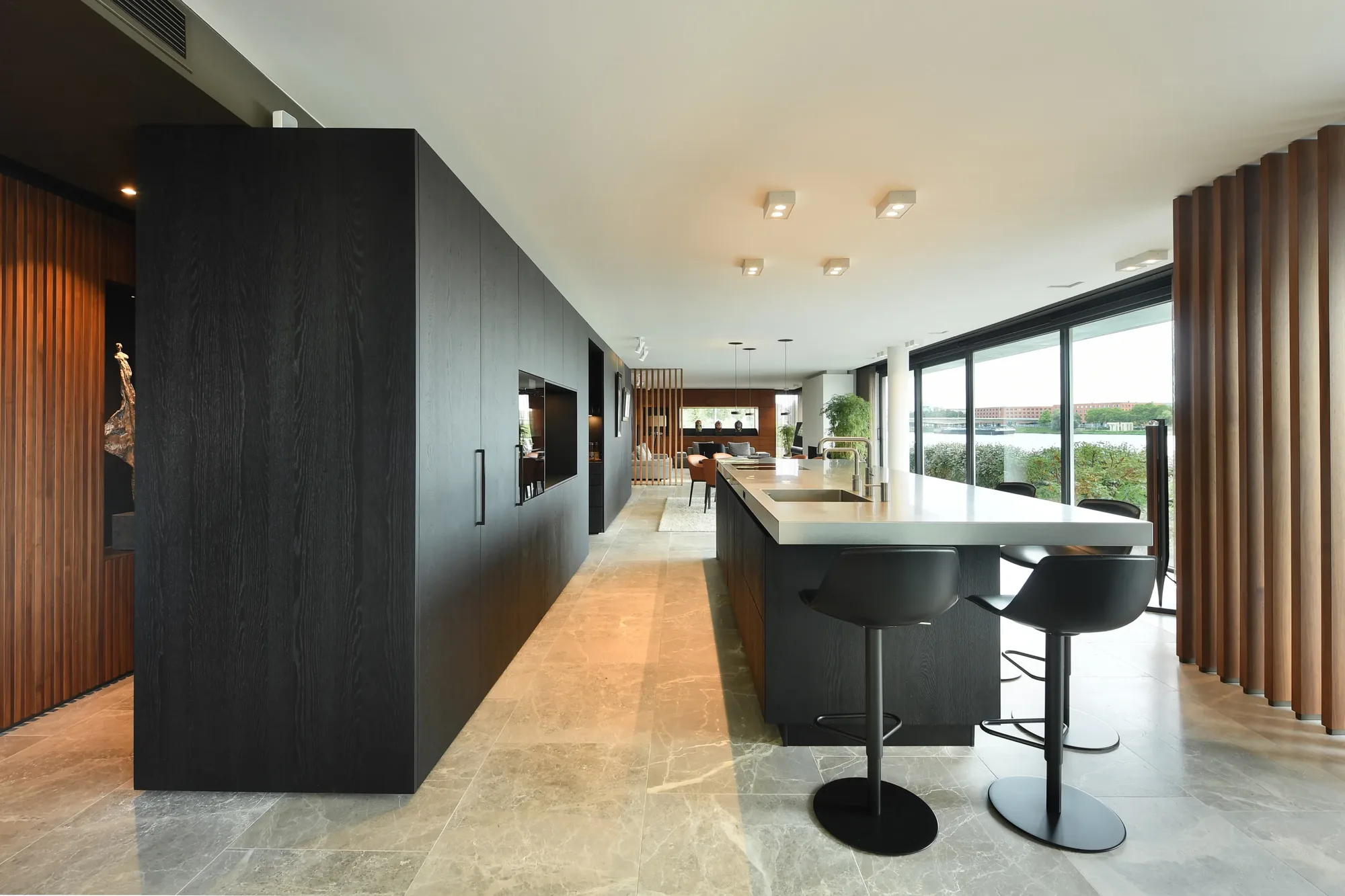 Luxe zwarte keuken met kookeiland dik RVS werkblad en houten wandpanelen ASWA Keukens 207129