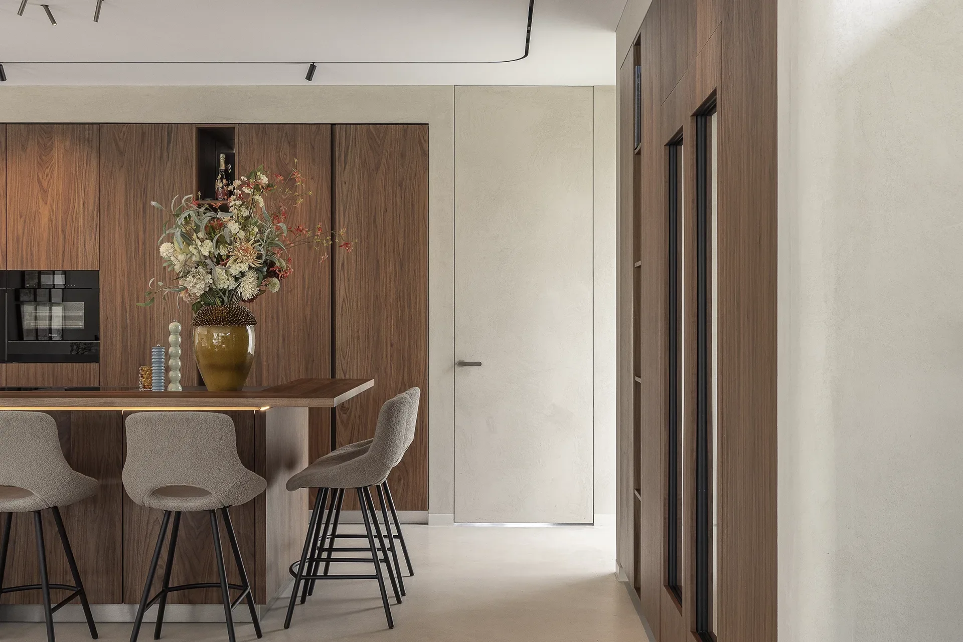 SieMatic woonkeuken met houtfineer, bar en warme natuurlijke materialen.