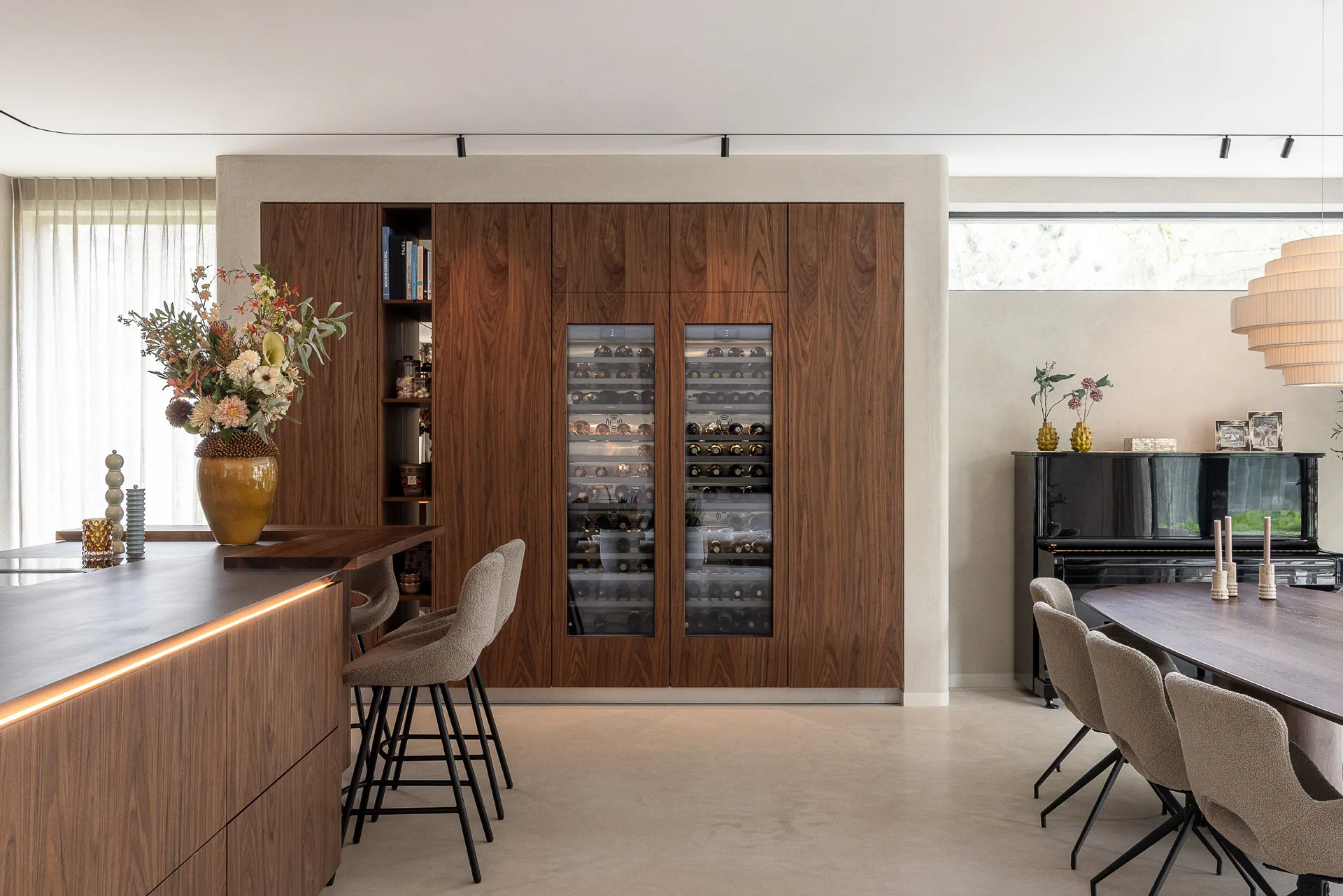 SieMatic woonkeuken met kookeiland, houtfineer en geïntegreerde wijnklimaatkasten.