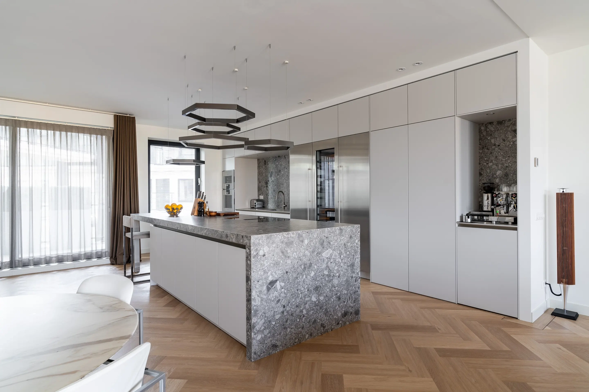 Chique witte SieMatic Classic keuken met kookeiland en natuurstenen werkblad in Amstelveen.