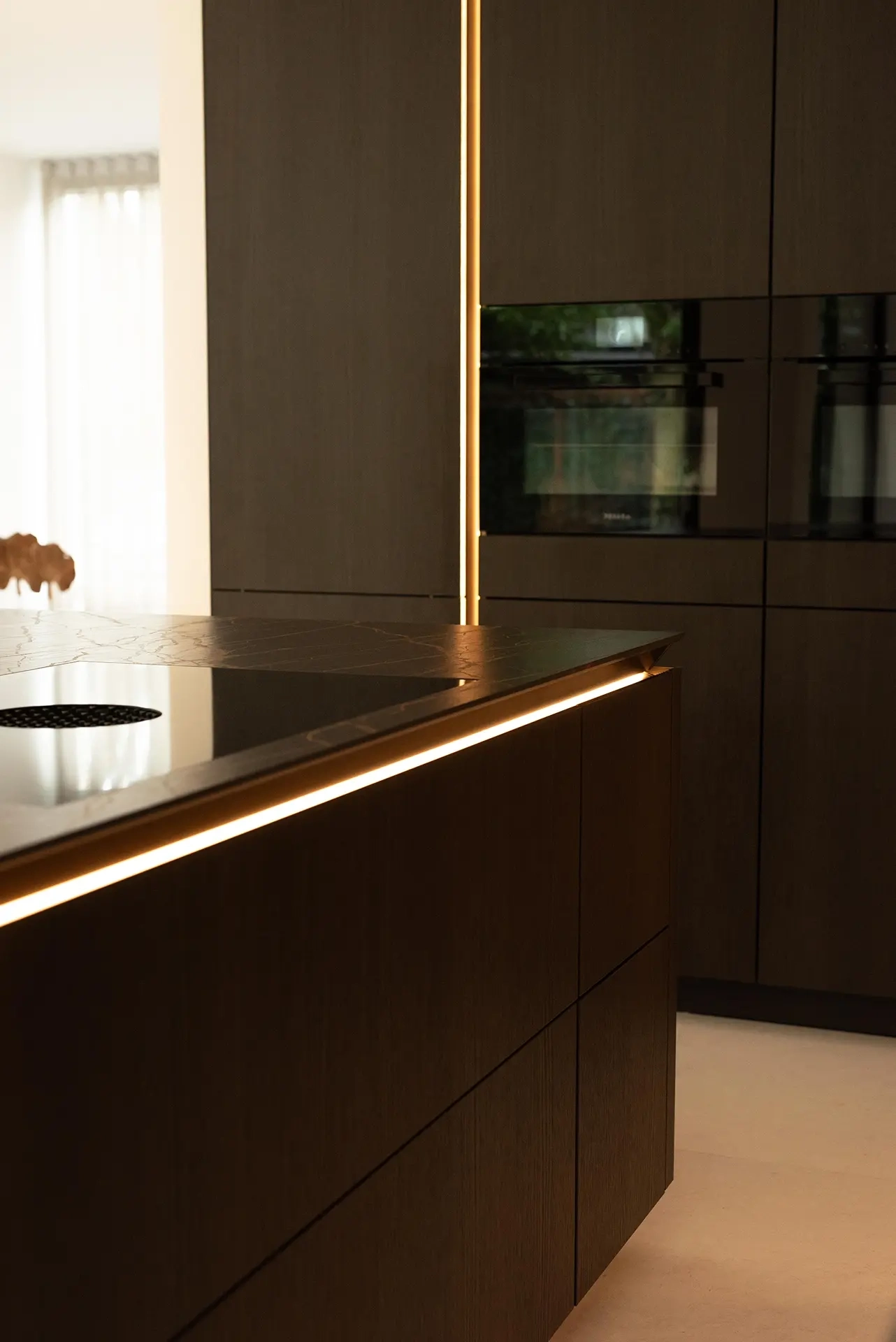 Detail van het Dekton Laurent werkblad en bronzen accenten in een SieMatic SLX keuken.