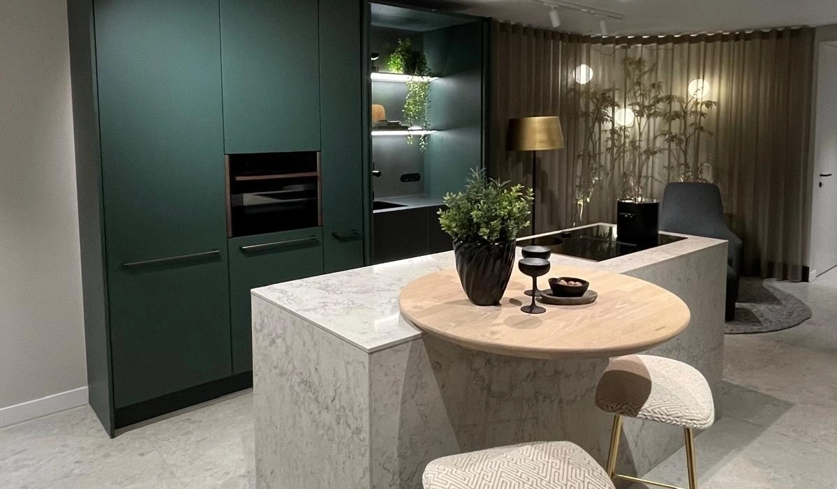 SieMatic showroomkeuken met kookeiland, natuurstenen look en groene fronten.