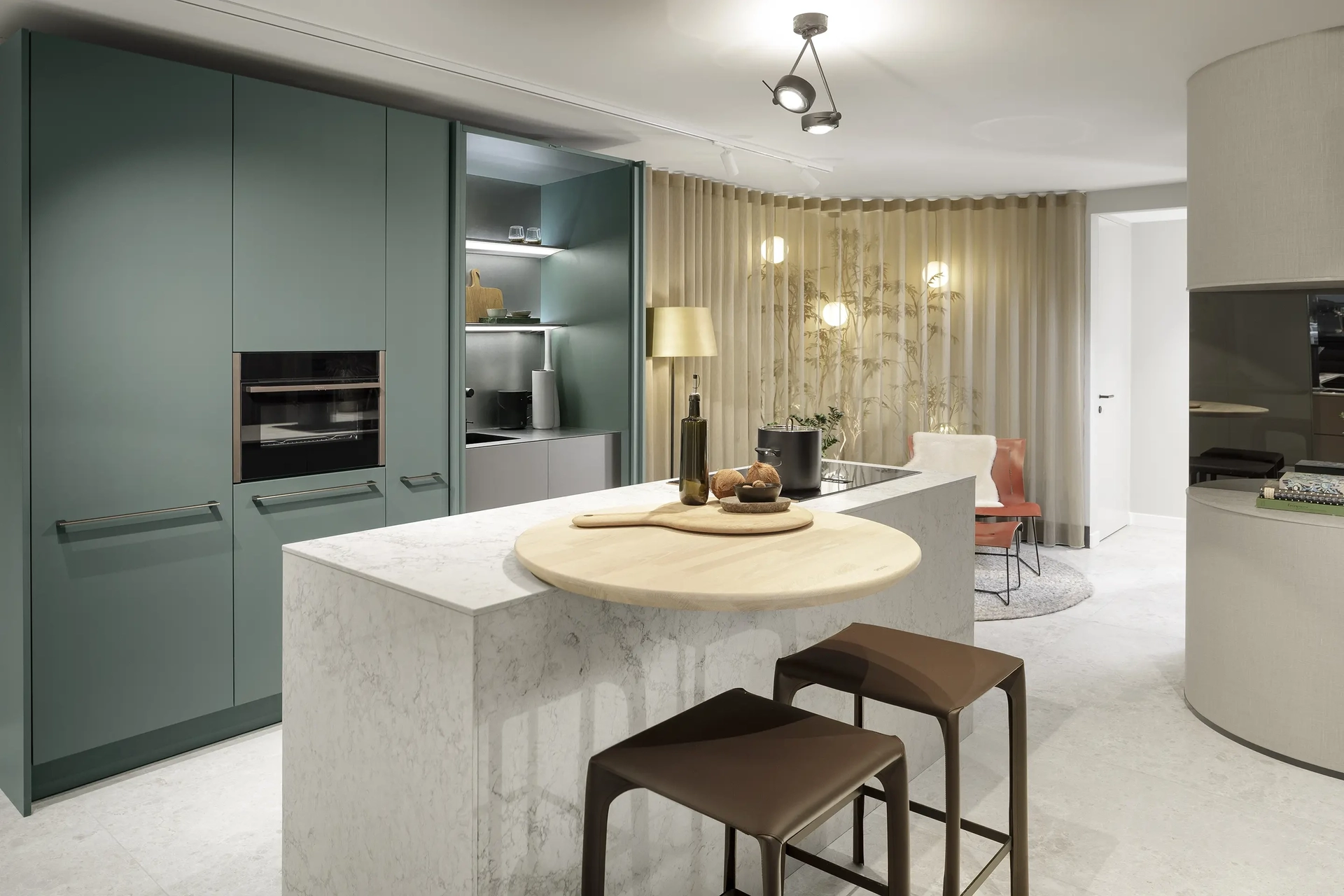 Luxe maatwerkkeuken in de SieMatic designstudio in Amsterdam met groene fronten en wit StoneDesign werkblad.