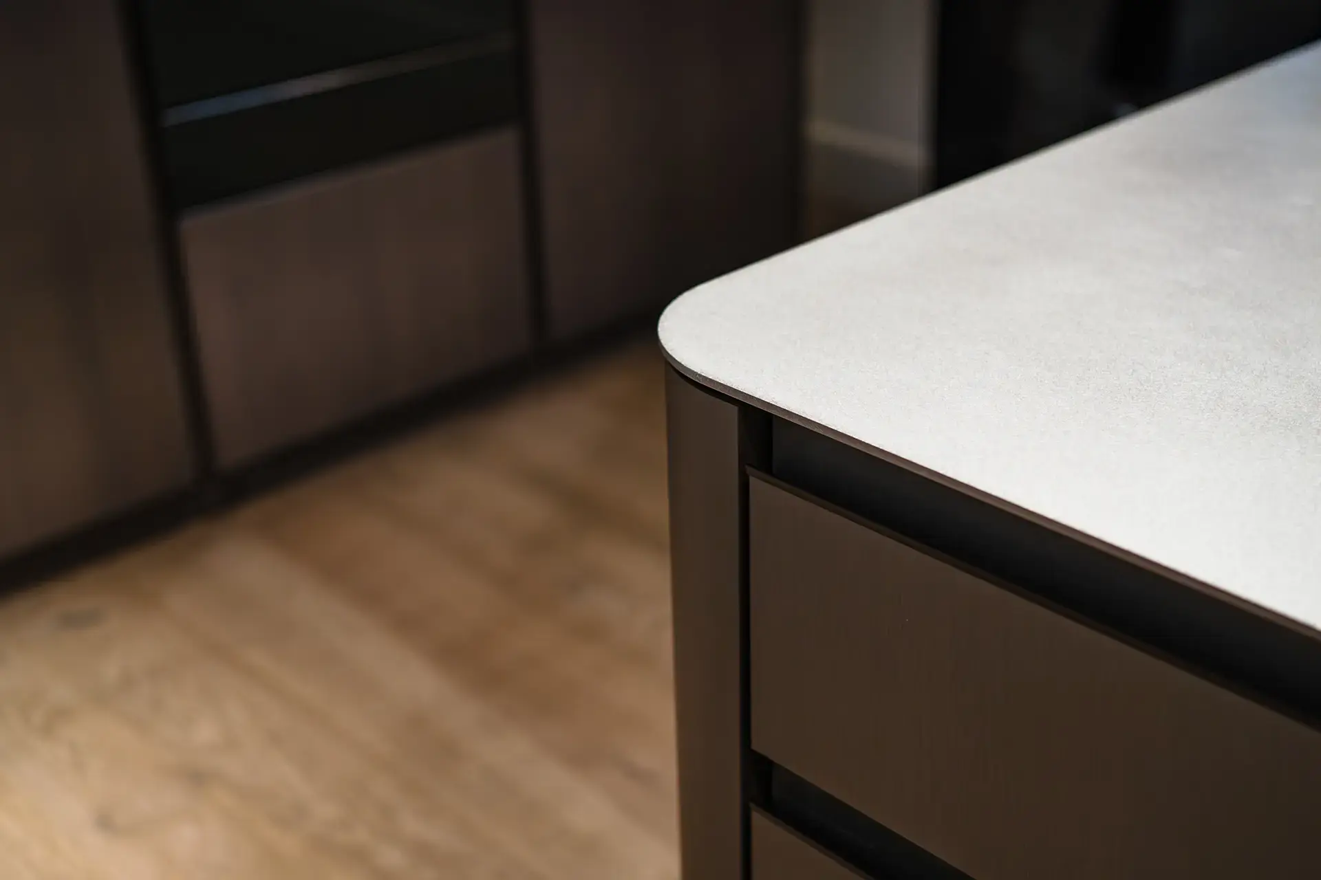 Detail van een SieMatic keuken met houtfineer, afgeronde hoek en natuurlijke materialen.