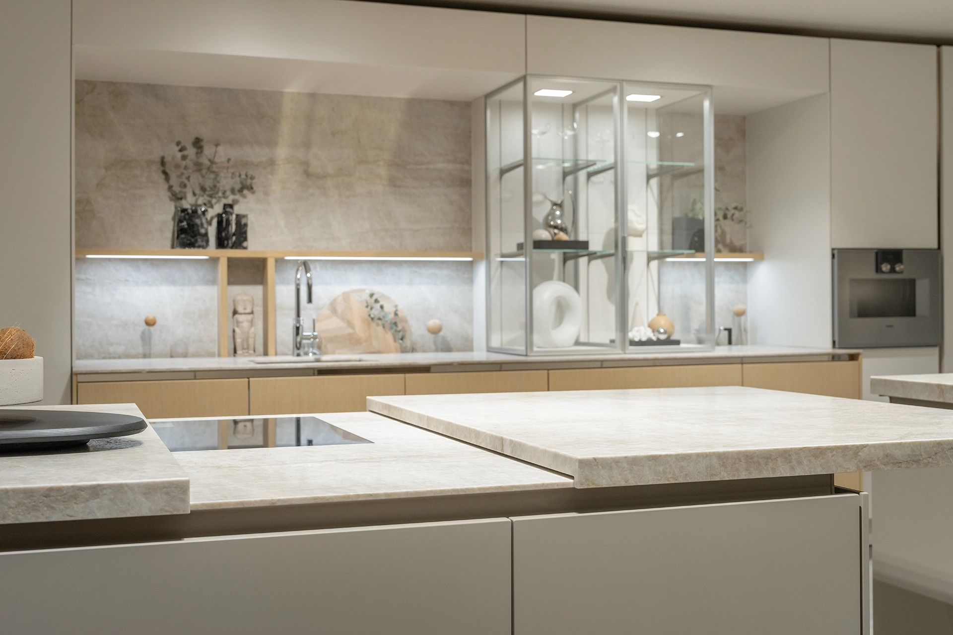 Detail van een greeploze SieMatic keuken met geïntegreerde vitrinekast en verfijnde afwerking.