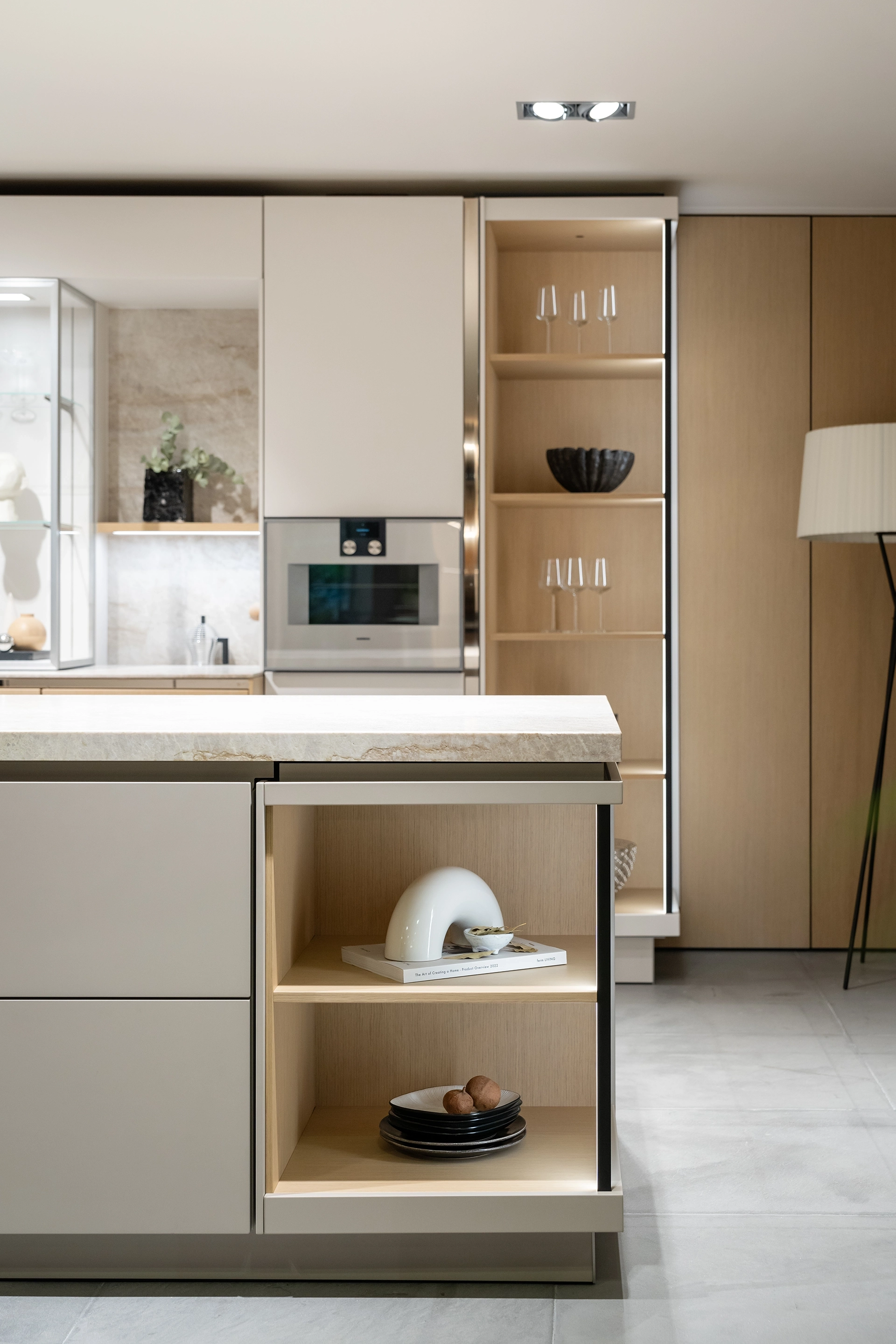 Modern SieMatic kitchen with light-colored cabinet fronts, open shelving, and a kitchen island.