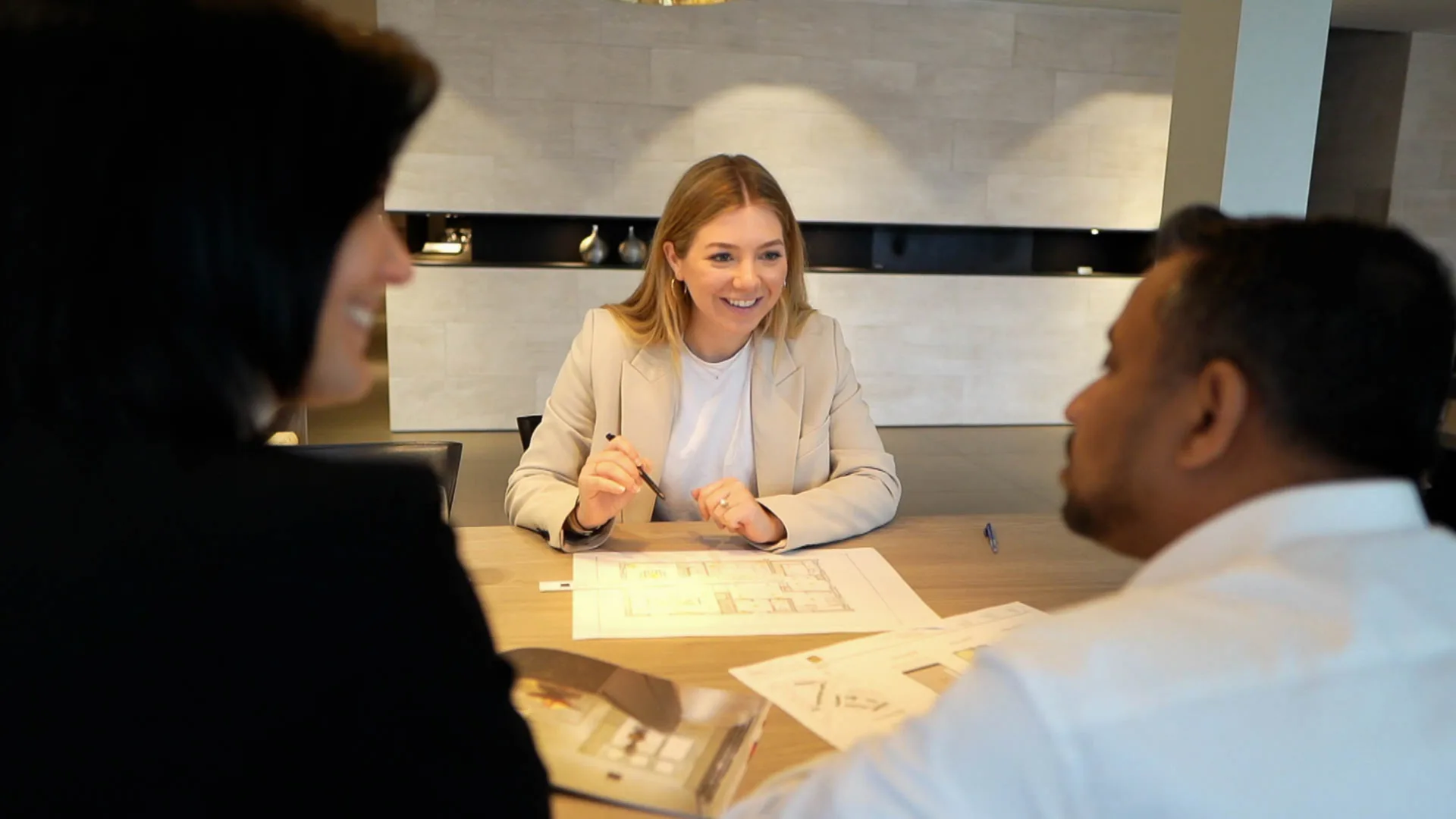 A kitchen designer discusses a personalized kitchen design with clients in the showroom.